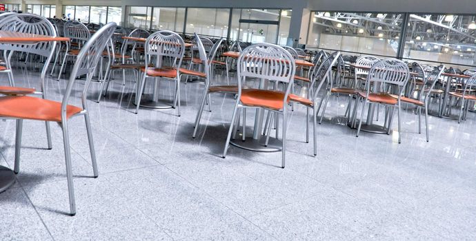 a lot of chairs and tables in fastfood cafe