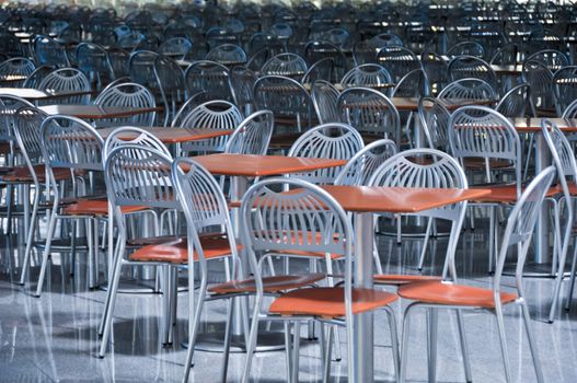 a lot of chairs and tables in fastfood cafe