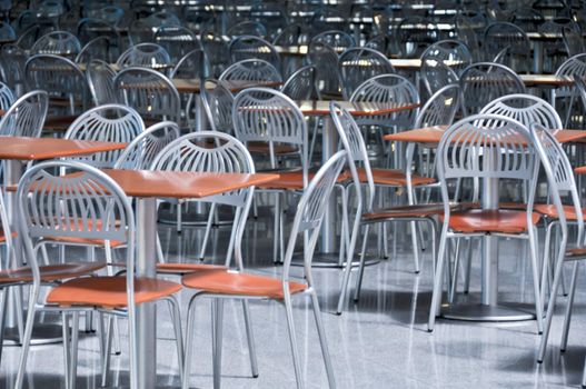 a lot of chairs and tables in fastfood cafe