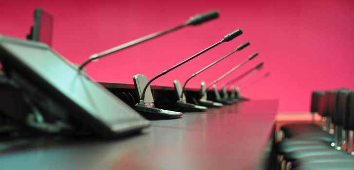 Conference table, microphones and office chairs, closeup, purple