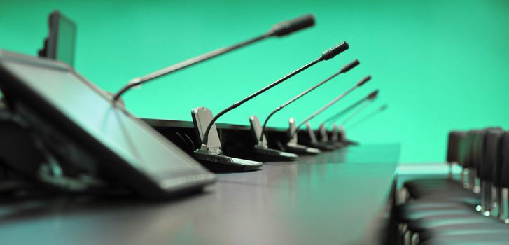 Conference table, microphones and office chairs, closeup, ultramarine