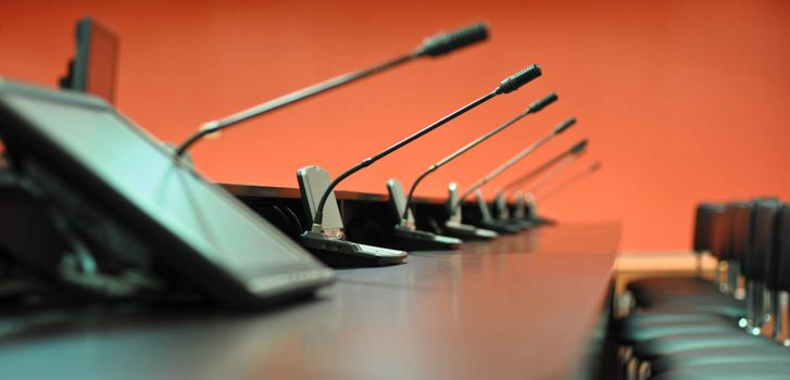 Conference table, microphones and office chairs close-up