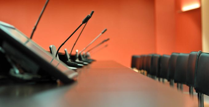 Conference table, microphones and office chairs close-up