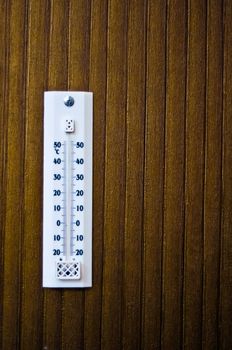 room thermometer on a wooden wall close up