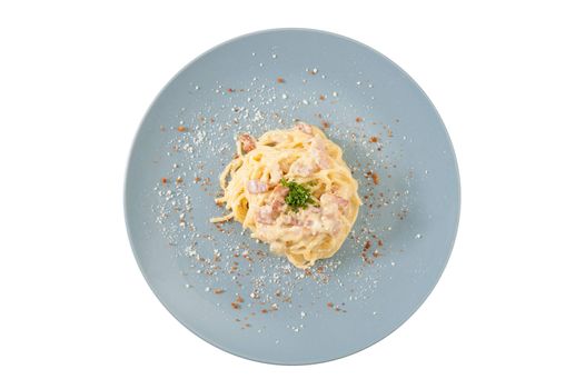 Carbonara pasta with bacon in grey ceramic dish isolated on white background with clipping path