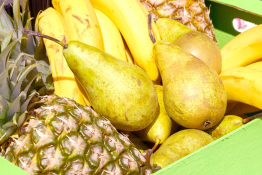 pears, pineapples, bananas in a wooden box