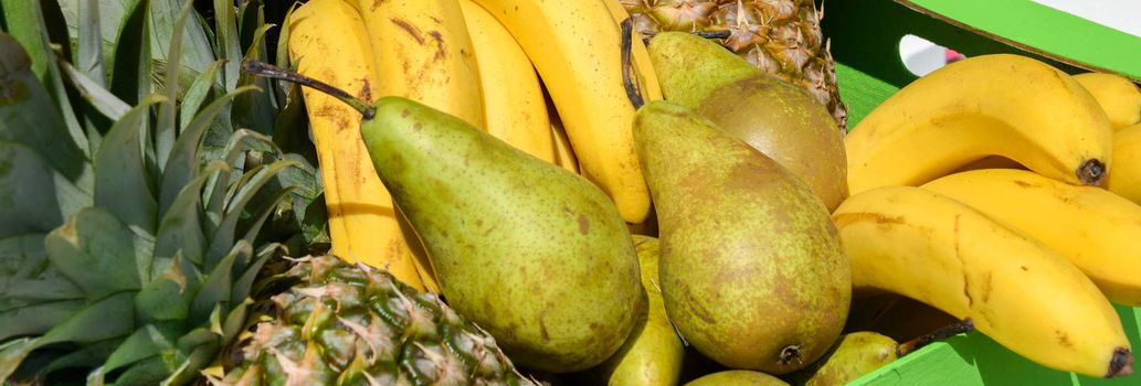 pears, pineapples, bananas in a wooden box