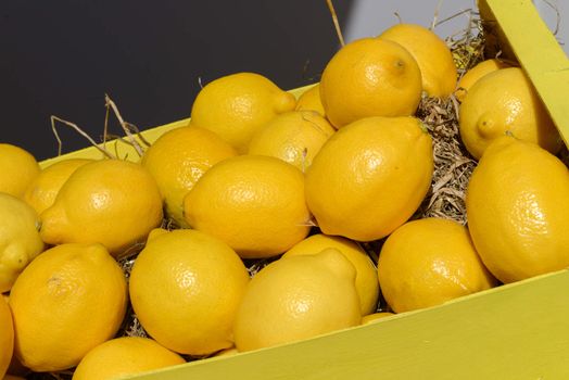 lot of ripe lemons in wooden crate