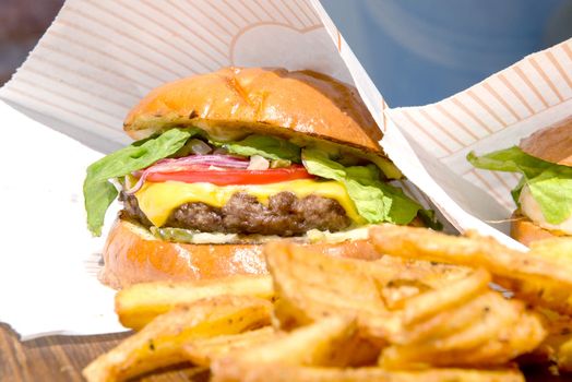 fresh burgers and fries on a wooden tray