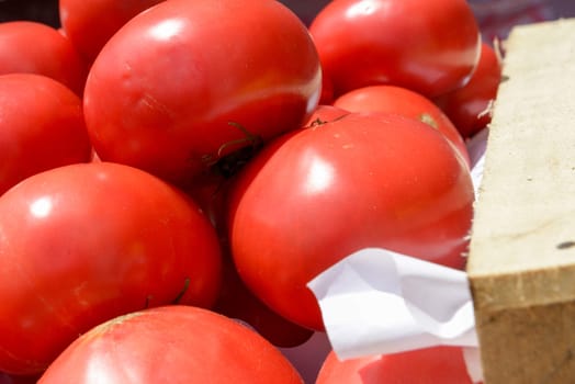 lot of ripe tomatoes in wooden crates close up