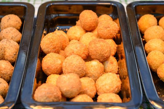 ruddy crispy cheese balls with spices in a metal tray