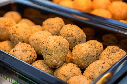 ruddy crispy cheese balls with spices in a metal tray