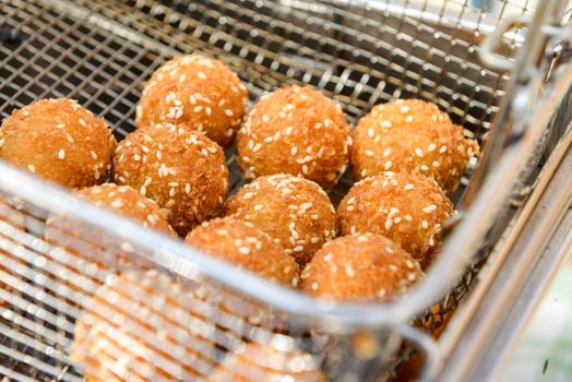 ruddy crispy cheese balls with spices in a metal grid