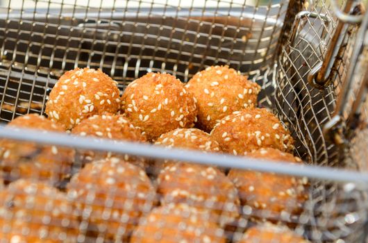 ruddy crispy cheese balls with spices in a metal grid