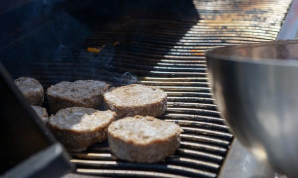 cooking steaks on a hot grill in a summer day