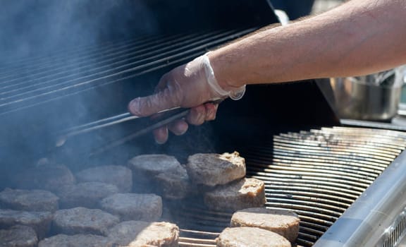 cooking steaks on a hot grill in a summer day