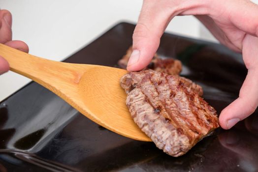 Delicious juicy steak on a black square plate