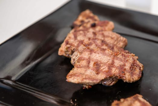 Delicious juicy steak on a black square plate