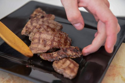 Delicious juicy steak on a black square plate