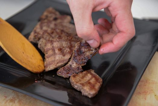 Delicious juicy steak on a black square plate