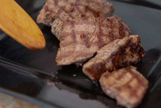 Delicious juicy steak on a black square plate