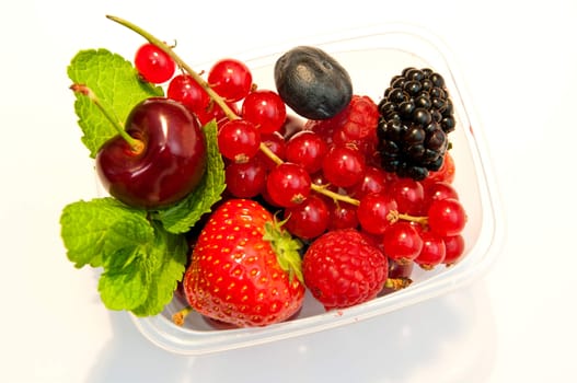 berries in a plastic box on a white background