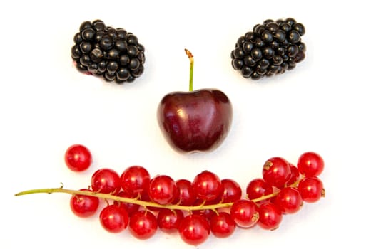 funny face from different berries on a white background