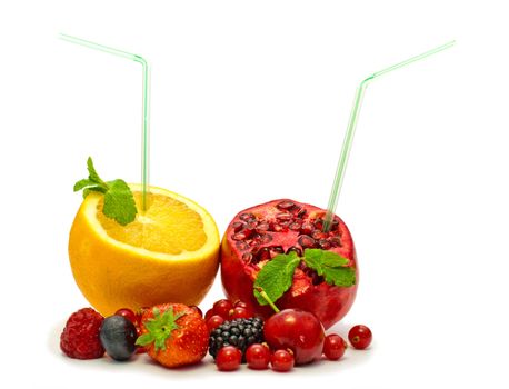 orange and pomegranate with a straw and berries on a white background