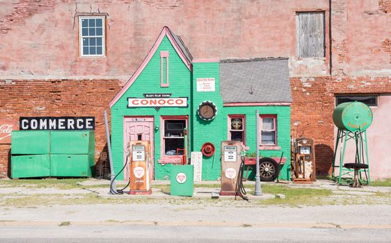 Historic quaint green Conoco garage with rusting pumps no longer in use in town of Commerce, Kansas, Route 66