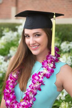 Pretty young adult female posing with graduation cap