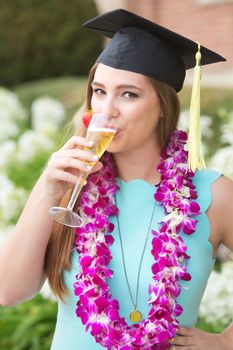 Graduate with pink boa sipping wine outdoors