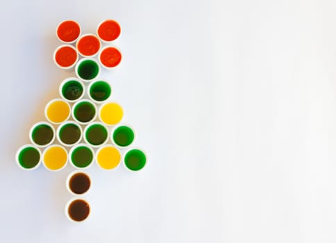 a tree made of glasses filled with colourful liquid reminiscent  a christmas tree