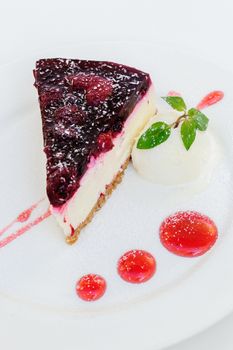 Cheesecake with raspberry sauce and green mint served on plate