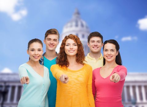 friendship, tourism, travel and people concept - group of smiling teenagers standing over white house background