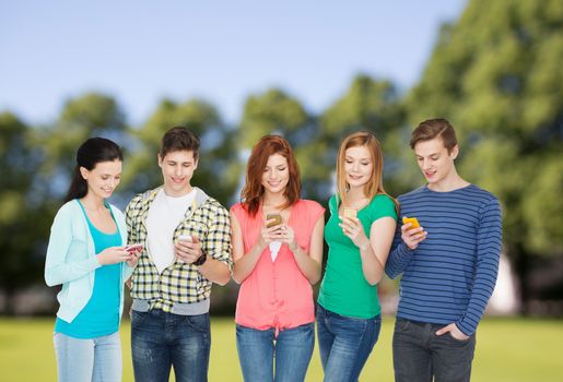 education and modern technology concept - smiling students with smartphones