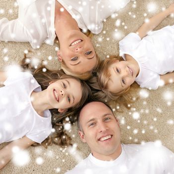 family, children and home concept - smiling family with and two little girls lying in circle on floor at home