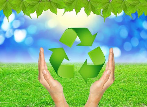 RECYCLE sign in hands against green spring background. Earth day concept