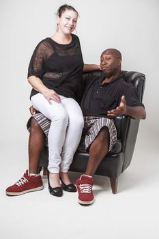 caucasian woman sitting on a black man lap