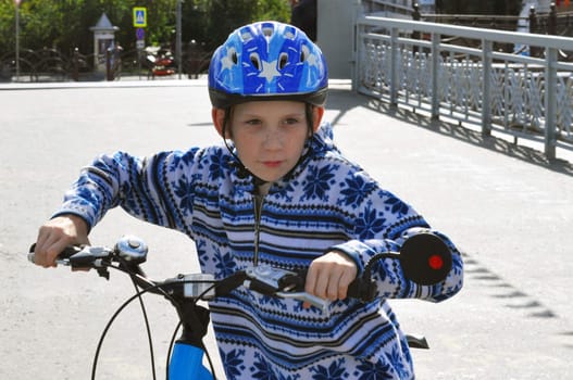 The teenage boy in a helmet and with bicycle.