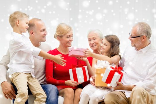 family, holidays, generation, christmas and people concept - smiling family giving each other presents at home