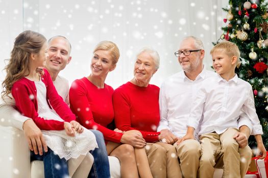 family, holidays, generation, christmas and people concept - smiling family sitting on couch at home