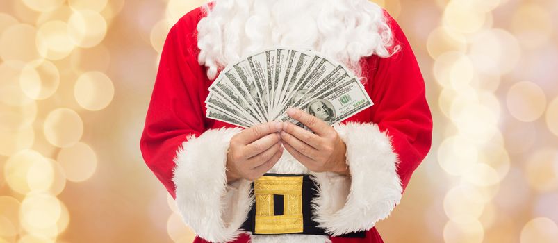 christmas, holidays, winning, currency and people concept - close up of santa claus with dollar money over beige lights background