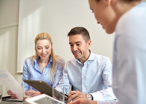 business, people, technology and teamwork concept - smiling businessman and businesswomen with tablet pc computer meeting in office