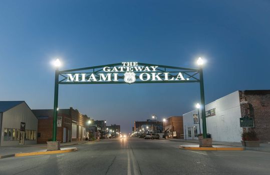 Miami, Oklahoma, USA - September 7, 2015; Gateway to Miami Oklahoma on Route 66. Entrance sign to the town through which the route runs along the main street at night with sign illuminated.