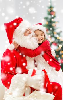 holidays, christmas, happiness and people concept - smiling girl with gift box embracing santa claus at home