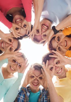 friendship, youth, gesture and people - group of smiling teenagers in circle having fun