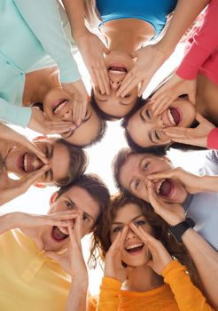 friendship, youth, gesture and people - group of smiling teenagers in circle shouting