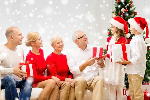 family, holidays, generation, christmas and people concept - smiling family with gift boxes sitting on couch at home