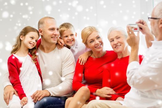 family, holidays, generation, christmas and people concept - smiling family with camera photographing and sitting on couch at home