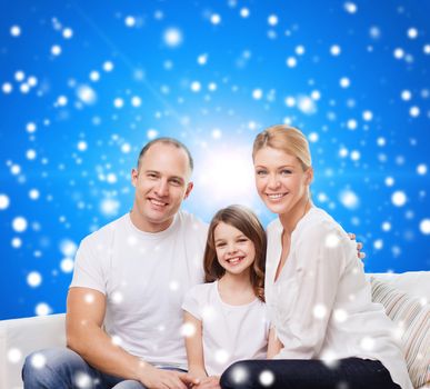 family, childhood, christmas holidays and people - smiling mother, father and little girl over blue snowy background